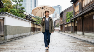金沢の街で、折り畳み傘と撥水ジャケットを準備して歩く日本人女性